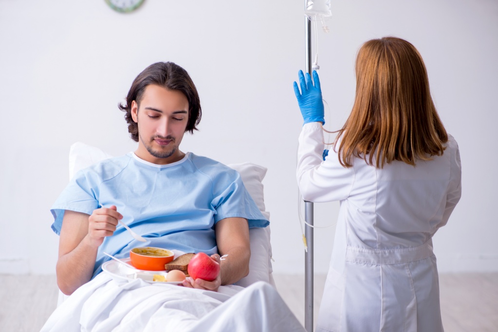 Пациент мужского пола ест пищу в больнице
